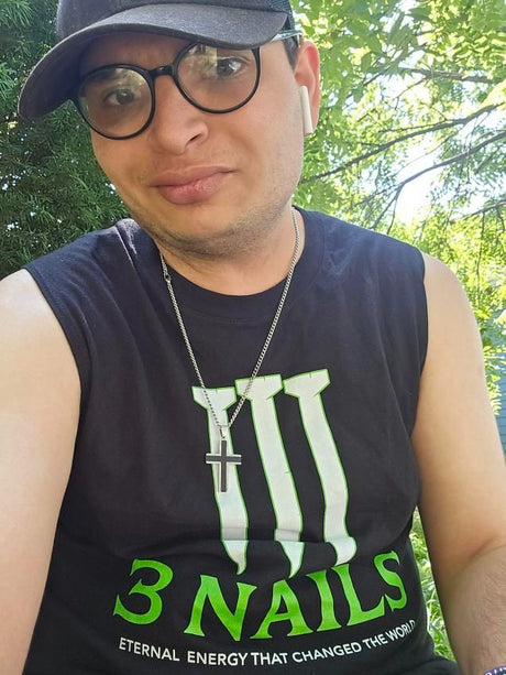Man wearing black and green Christian muscle shirt with ‘3 Nails – Eternal Energy That Changed the World’ design, inspired by energy drink branding.