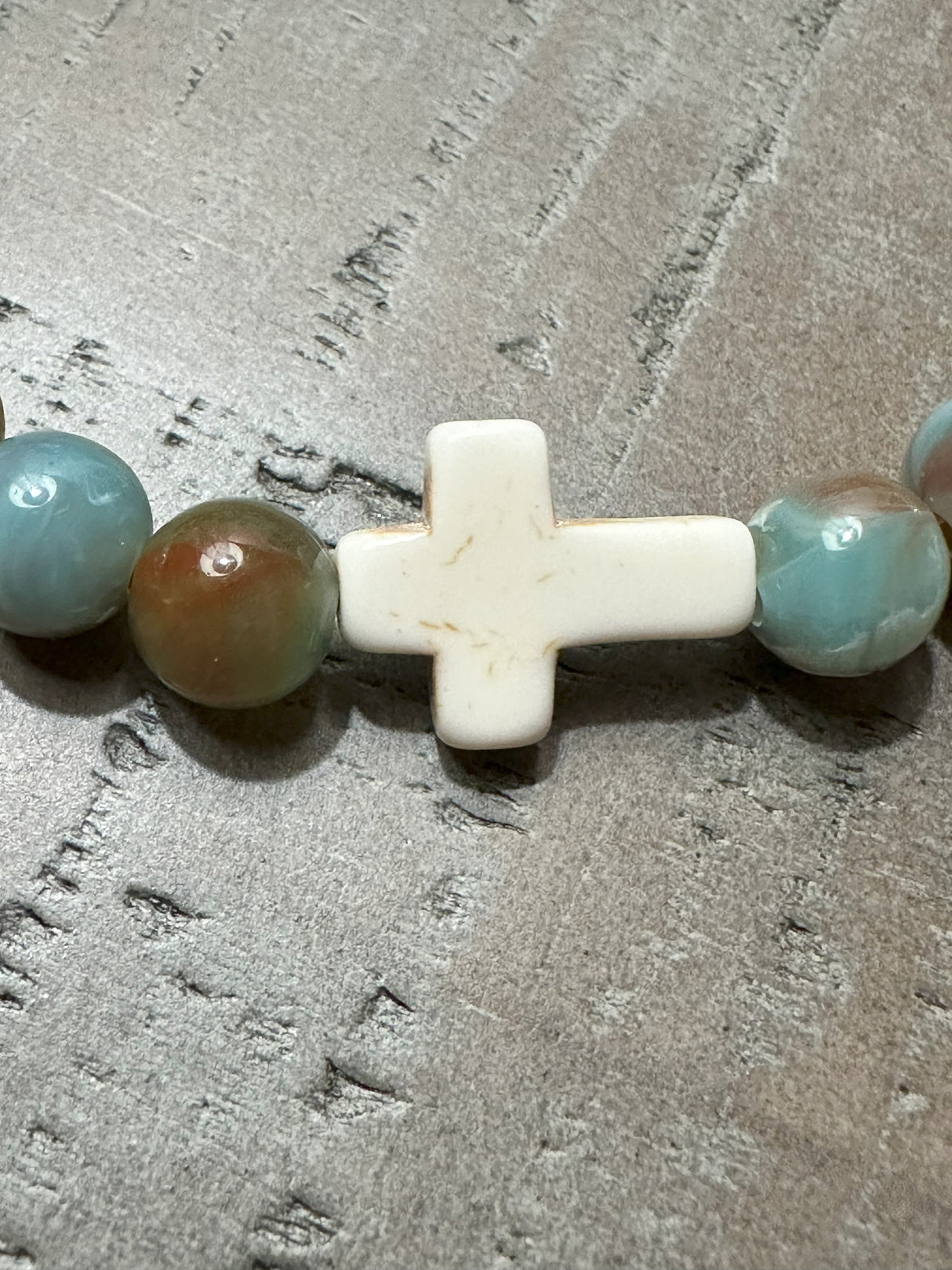 Salt and Light Merch Christian bracelet – polished gemstone beads in soft blush and champagne tones with a rhinestone cross charm. Shown in a close-up product photo for Christian faith jewelry.