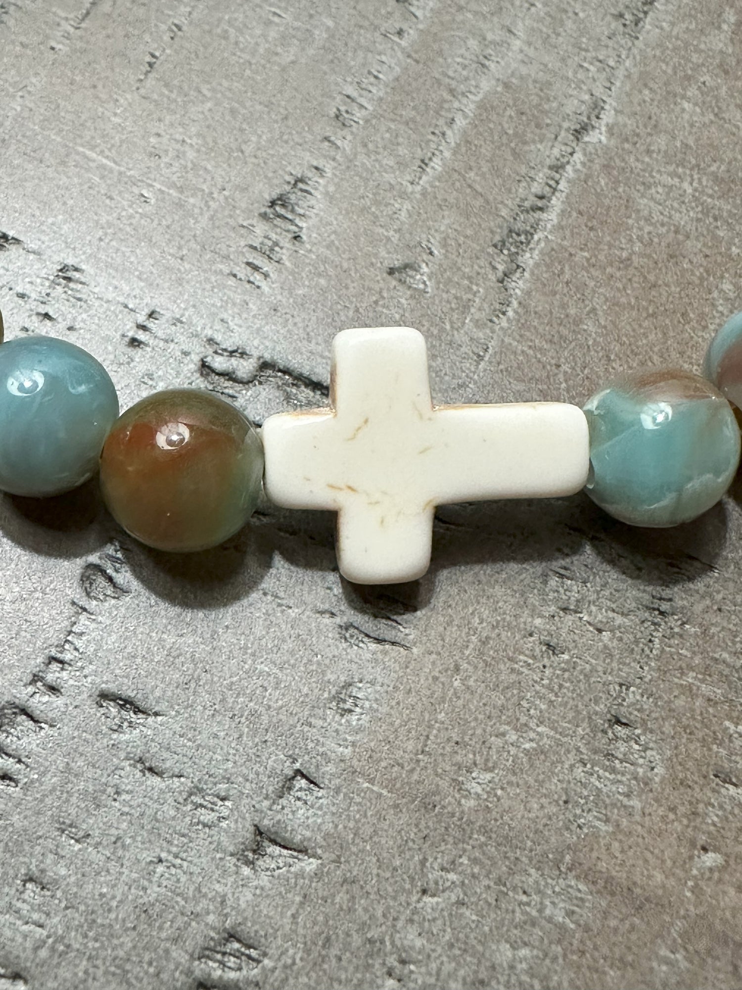 Salt and Light Merch Christian bracelet – polished gemstone beads in soft blush and champagne tones with a rhinestone cross charm. Shown in a close-up product photo for Christian faith jewelry.