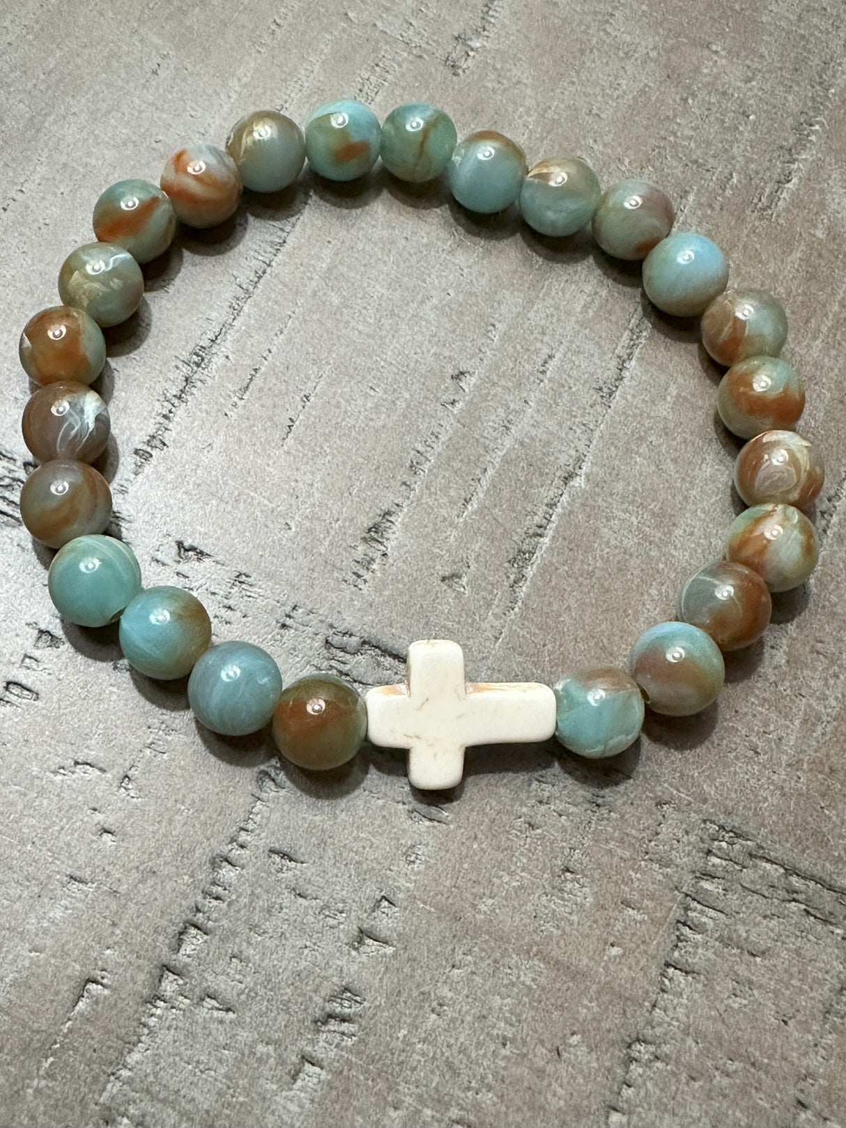 Salt and Light Merch Christian bracelet – polished gemstone beads in soft blush and champagne tones with a rhinestone cross charm. Shown in a close-up product photo for Christian faith jewelry.