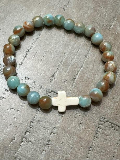 Salt and Light Merch Christian bracelet – polished gemstone beads in soft blush and champagne tones with a rhinestone cross charm. Shown in a close-up product photo for Christian faith jewelry.